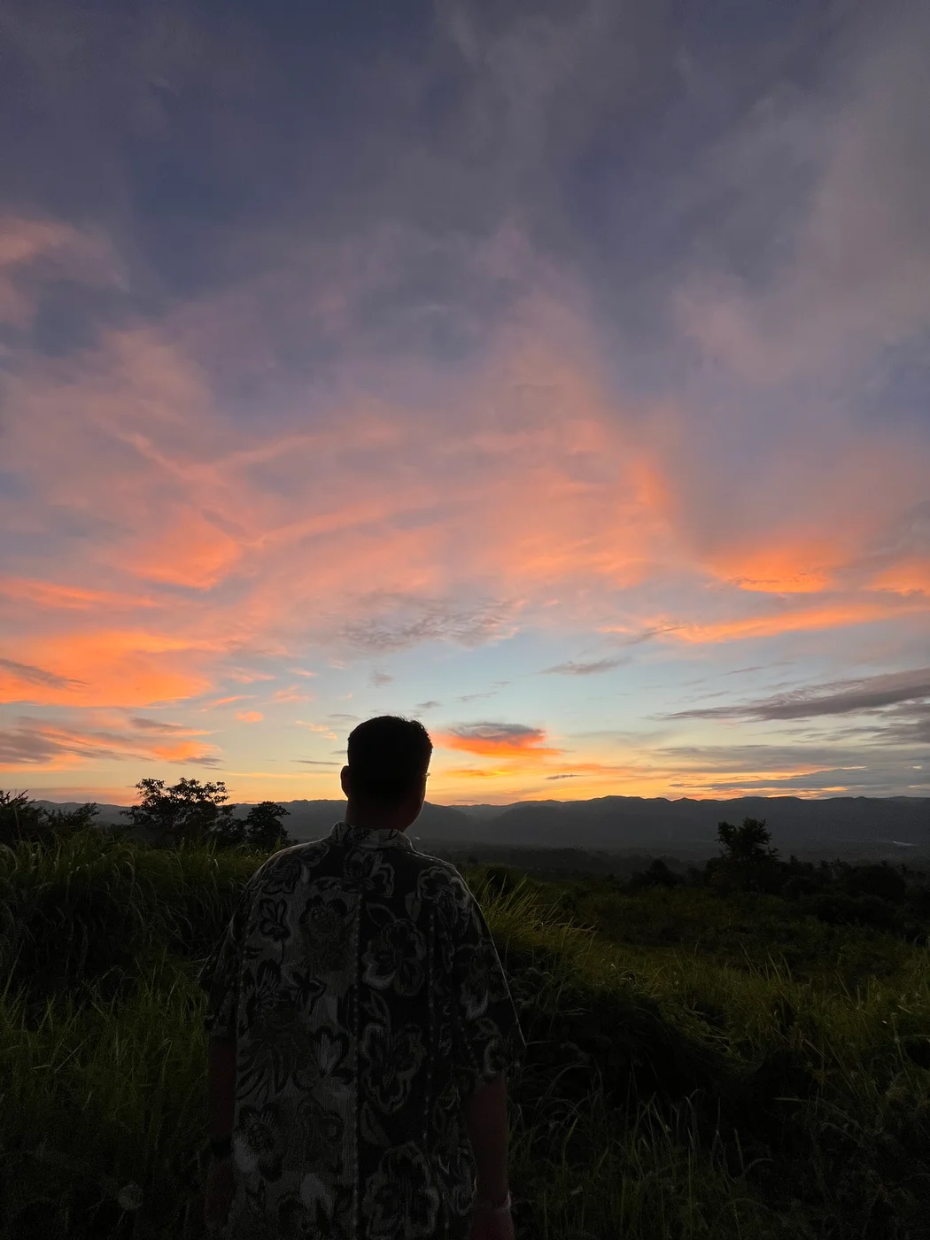 Alex looking toward the horizon under a colorful evening sky