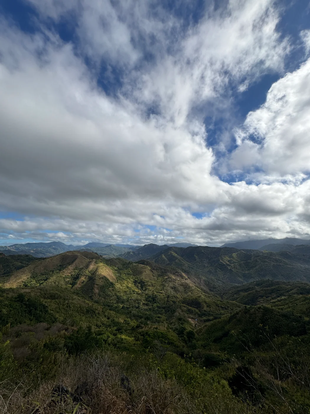 Layered mountain ridges under a dramatic cloud-filled sky