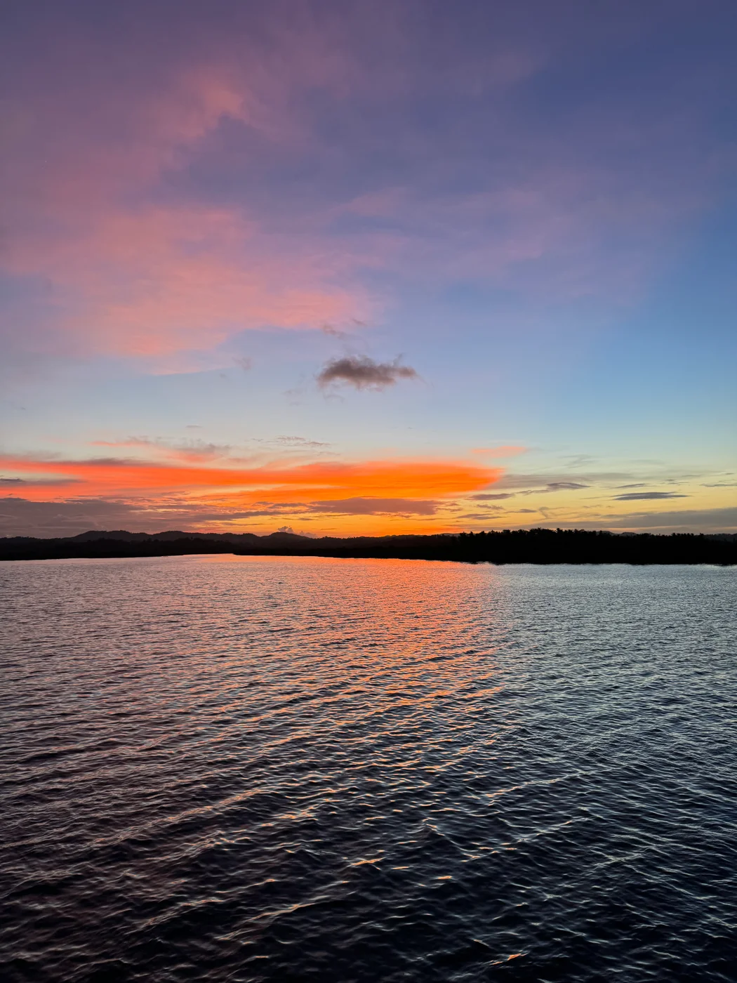 Orange and pink sunset reflected on calm water